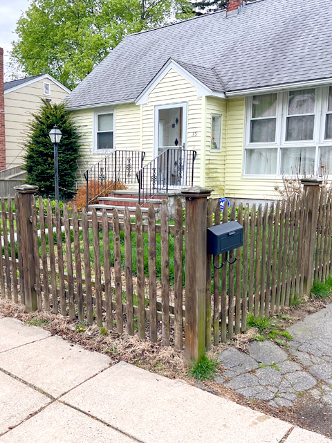 House with a messy front yard and old fence